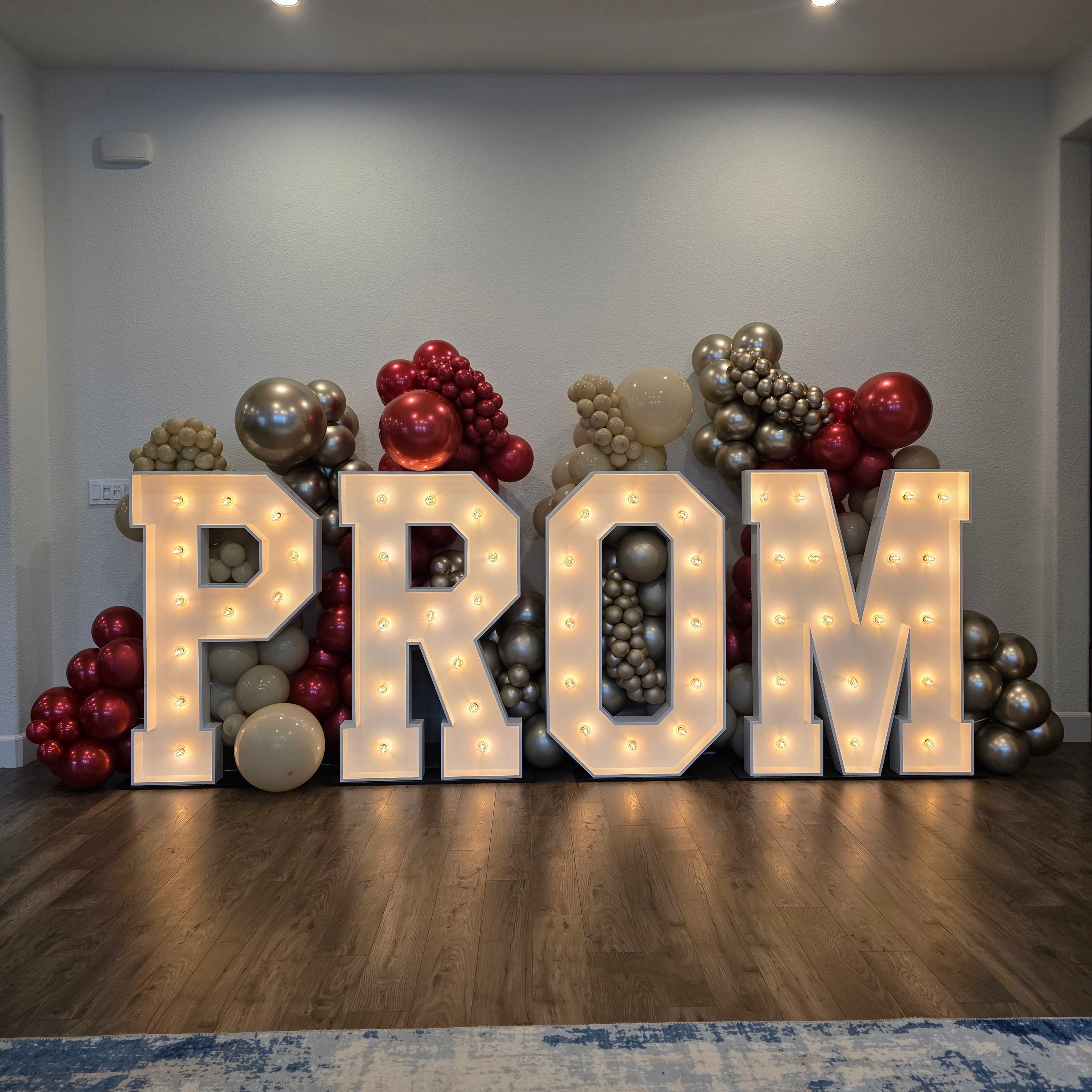 Decorative 'PROM' sign with balloons on a wall.