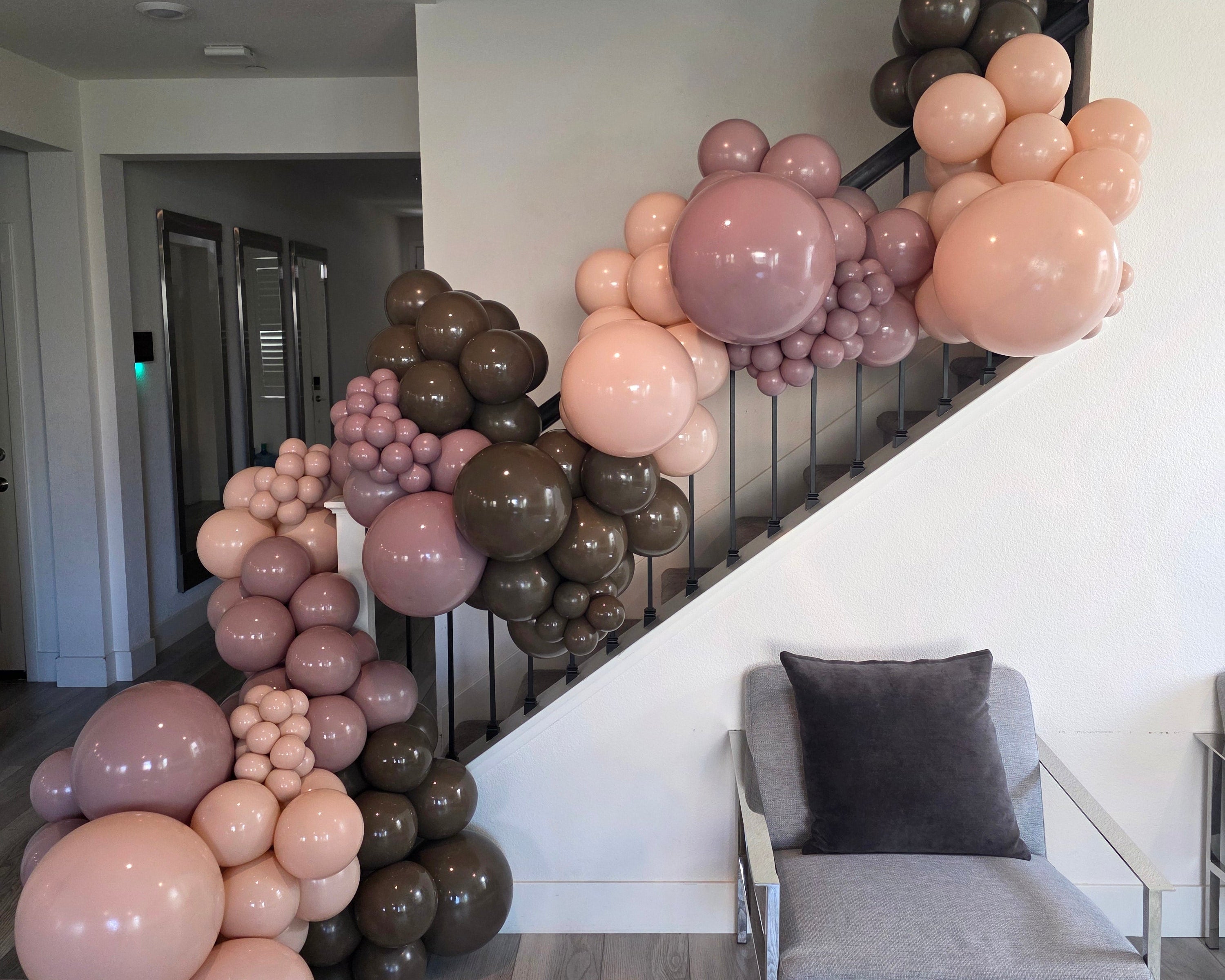 Balloon arch in a staircase with pink and brown balloons
